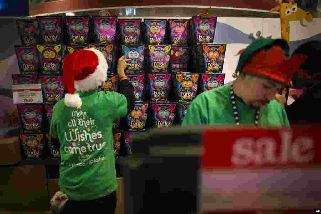 Employees stock Furby dolls behind a register at the Times Square Toys R' Us, New York, Nov. 28, 2013.