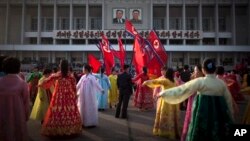 Seorang pria (tengah) memeriksa sekelompok penari saat menggelar tari rakyat di depan Stadion di Pyongyang, Korea Utara. Rakyat Korea Utara merayakan ulang tahun ke 101 kelahiran Kim Il Sung, pendiri negara Stalinis tersebut, Senin (15/4).