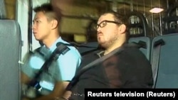 Rurik Jutting, 29, right, a British banker who has been charged with two counts of murder, sits in a police van as it arrives at a court in Hong Kong, Nov. 3, 2014.