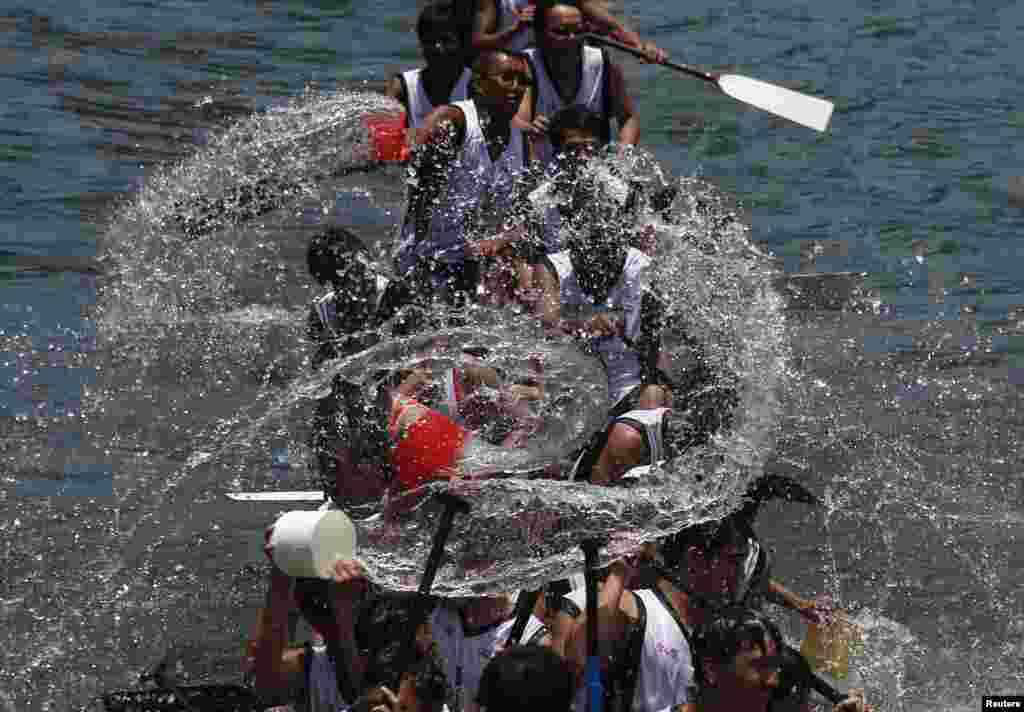 Participants splash water from their dragon boats as part of the celebration to mark the annual Tuen Ng or Dragon Boat Festival at Hong Kong&#39;s Aberdeen. The festival is commemorated in memory of Chinese patriotic poet Qu Yuan, who drowned himself on the day in 277 B.C.