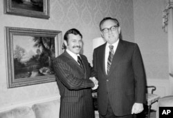 FILE - Abdelaziz Bouteflika, left, meets with U.S. Secretary of State Henry Kissinger at the U.S. State Department suite at the Waldorf Astoria Hotel Towers, Oct. 1, 1975.