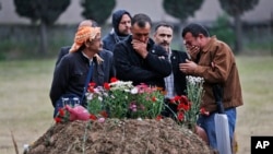 Relatives gather at the grave of a loved one killed in the mine explosion in Soma, Turkey, May 17, 2014. 