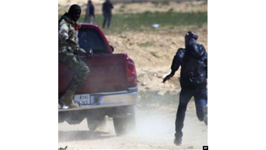 Libyan rebels run to take cover as mortars from Moammar Gadhafi's forces are fired on them on the frontline near Zwitina, the outskirts of the city of Ajdabiya, south of Benghazi, eastern Libya, Mar 23 2011