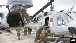 In this image released by the U.S. Marine Corps on Wednesday Aug. 29, 2012, Marines from Marine Light Attack Helicopter Squadron 467 (HMLA-467) unload a UH-1N Huey helicopter in Guatemala City, Aug. 11, 2012. A team of 200 U.S. Marines and four UH-1N Hu