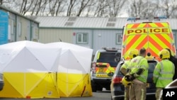 Fire officers stand inside a cordon at the vehicle recovery business "Ashley Wood Recovery" in Salisbury, England, March 13, 2018.