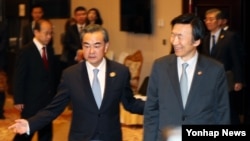 왕이 중국 외교부장(왼쪽)과 윤병세 한국 외교장관이 25일 라오스 비엔티안에서 양자회담 장소로 입장하고 있다.