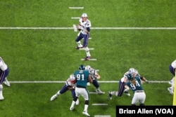 ຄົວເຕີແບກ ທ້າວ ທອມ ເບຣດີ (Tom Brady) ຖອຍໄປຕັ້ງທ່າ ກຽມຈະແກວ່ງບານ ໃນຕັ້ງທີສາມ ຂອງການແຂ່ງຂັນຊິງແຊ້ມປ້ຽນ ຊຸບເປີ ໂບລ Super Bowl ຄັ້ງທີ 52 ພາບຖ່າຍໂດຍ (Brian Allen/VOA)