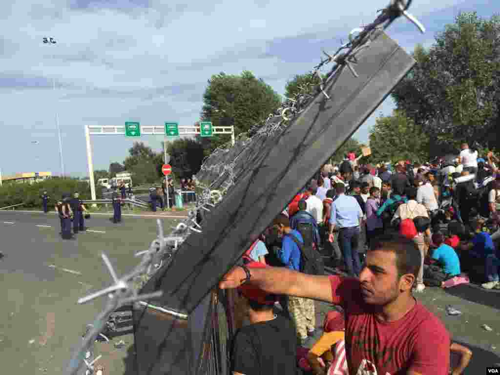 Refugees and migrants find themselves stuck at the Serbia-Hungary border crossing after it's been shut down, Sept. 15, 2015. (Henry Ridgwell/VOA)