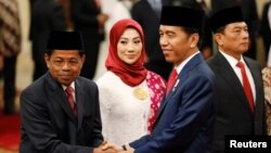 Presiden Joko Widodo berjabat tangan dengan Menteri Sosial yang baru Idrus Marham usai pelantikan di Istana Negara, Rabu (17/1). 