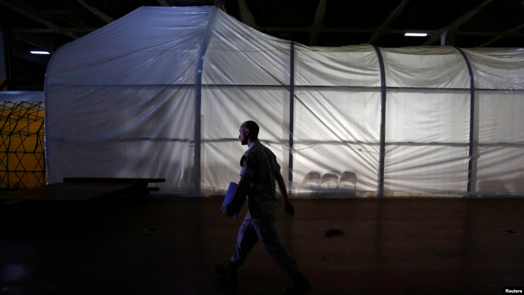 FILE - A U.S. Marine officer walks past the Field Deployable Hidrolysis System (FDHS) of the U.S. MV Cape Ray ship docked at the naval airbase in Rota, near Cadiz, southern Spain.