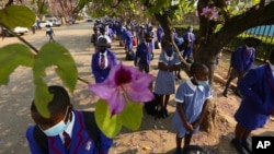 FILE: Schoolchildren wait to enter their school in Harare, Zimbabwe, Monday Sept, 28, 2020. Zimbabwe schools have reopened in phases, but with smaller number of pupils, more teachers and other related measures to enable children to resume their education withou