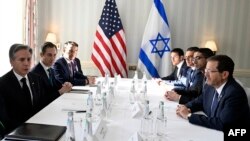 El secretario de Estado de Estados Unidos, Antony Blinken, a la izquierda, y el Presidente de Israel, Isaac Herzog, a la derecha, conversan junto a miembros de sus delegaciones en Munich, Alemania, este sábado 17 de febrero de 2024.
