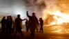 Police guard the area as some buildings are set on fire after the announcement of the grand jury decision, in Ferguson, Missouri, Nov. 24, 2014.