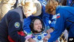 Astronot Steven Swanson (tengah) dibantu oleh dokter-dokter Rusia seusai pendaratan dengan Soyuz TMA-12M di dekat kota Zhezkazgan, Kazakhstan (11/9).