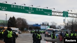 캐나다 온타리오주에서 미국으로 넘어가는 앰배서더 다리 연결로에서 지난 12일 현지 경찰이 차량 점거 시위대를 통제하고 있다.