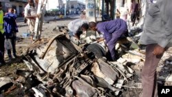 Somalian police examine the wreckage of the car after car bomb exploded in Mogadishu, Somalia, April 17, 2019.