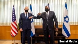 Pentagon chief Lloyd Austin, right, and Israeli Secretary of Defense Benny Ganz elbow-bump before their meeting in Tel Aviv, April 11, 2021. (Twitter/@SecDef)