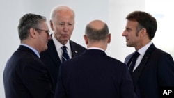 FILE - British Prime Minister Keir Starmer, from left, US President Joe Biden, German Chancellor Olaf Scholz and French President Emmanuel Macron speak before attending their Quad meeting at the Chancellery in Berlin, on Oct. 18, 2024.