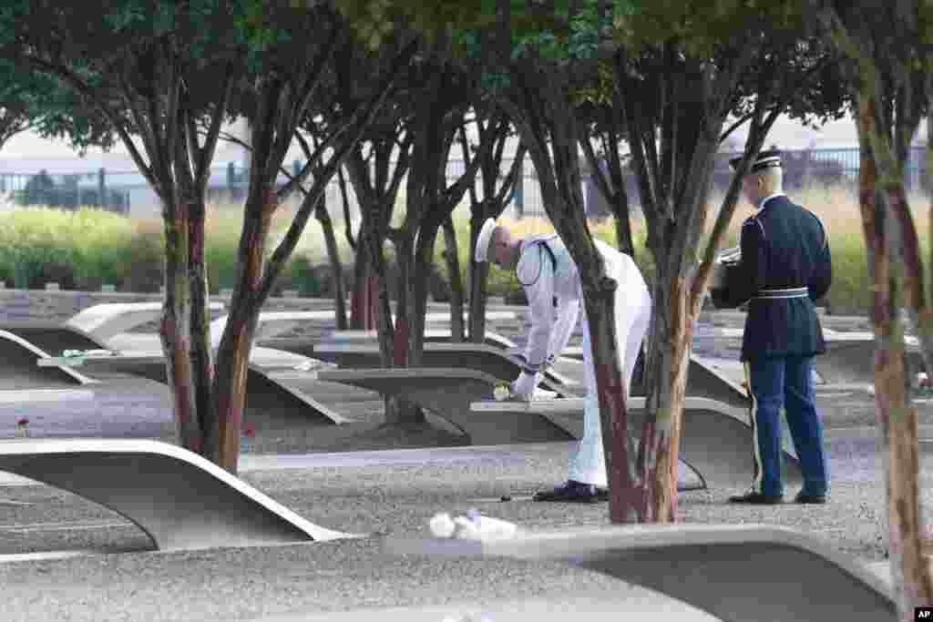 Members of the military honor guard place roses on top of the memorial benches at the 9/11 Pentagon Memorial, in Washington,&nbsp;Sept. 11, 2024.