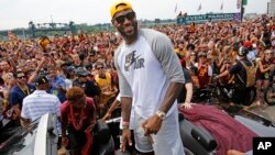 Cleveland superstar LeBron James, center, stands in the back of a Rolls Royce at the beginning of a parade in downtown Cleveland, Wedensday, June 22, 2016, celebrating the Cavaliers' NBA Championship.