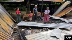 Una familia permanece en medio de los escombros de su casa, incendiada en un ataque de un grupo armado, en la vereda Cubilguitz, municipio de Cobán, departamento de Alta Verapaz, Guatemala, el 18 de agosto de 2020.