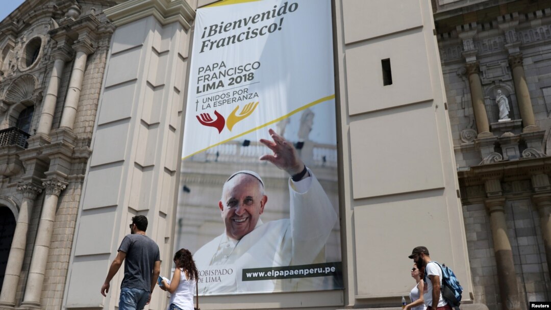 People walk past Lima Cathedral with a banner of Pope Francis before his visit to Peru, Jan. 18-21, in Lima, Peru, Jan. 12, 2018.