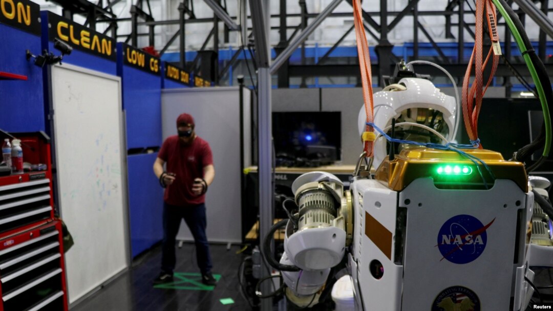 El ingeniero de software de la NASA, Ian Chase, controla el robot humanoide Valkyrie con un casco de realidad virtual y controladores en el Centro Espacial Johnson en Houston.