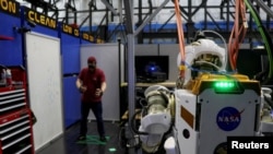 El ingeniero de software de la NASA, Ian Chase, controla el robot humanoide Valkyrie con un casco de realidad virtual y controladores en el Centro Espacial Johnson en Houston.