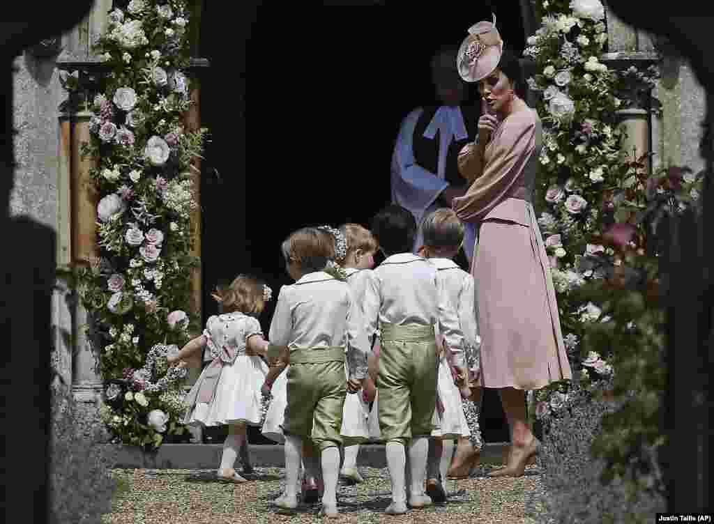 La británica Catherine, duquesa de Cambridge, a la derecha, hace gestos mientras camina con las damas de honor al llegar a la boda de su hermana Pippa Middleton con James Matthews, en la iglesia de San Marcos en Englefield, Inglaterra, el 20 de mayo de 2017.