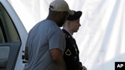 Army Pfc. Bradley Manning, right, is escorted into a courthouse in Fort Meade, Maryland, before a court martial hearing, July 18, 2013.