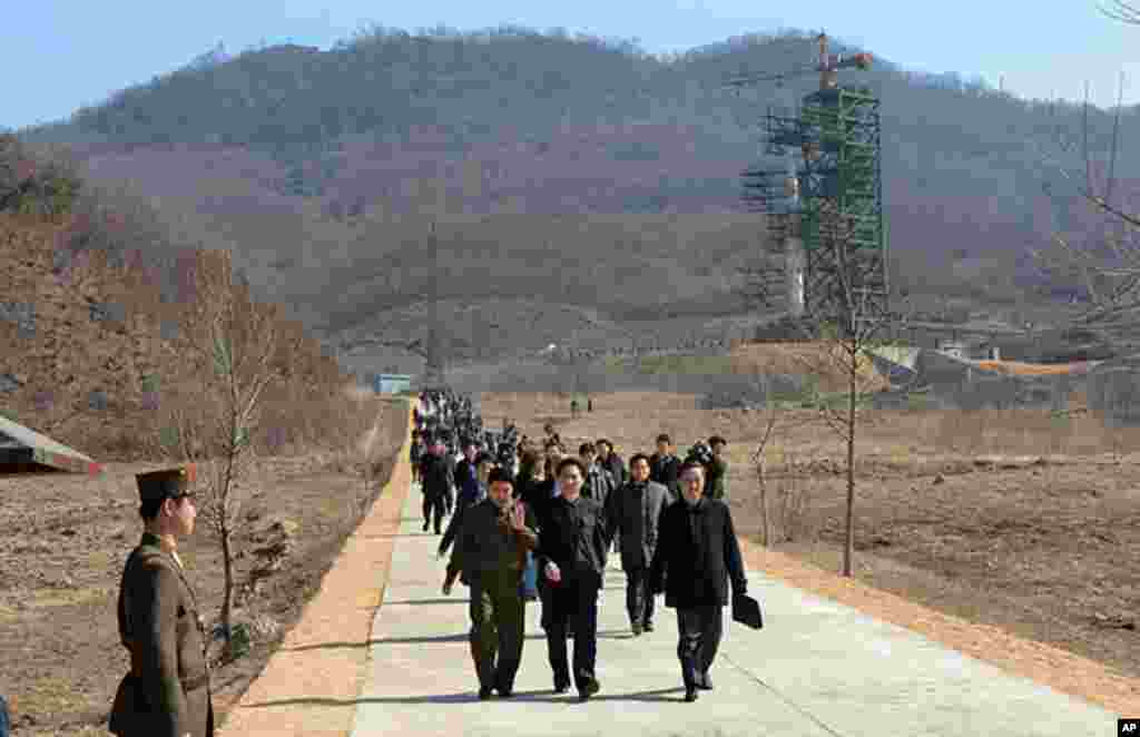 North Korean officials and foreign journalists leave the launch pad after a visit to see the rocket Unha-3 at Tangachai -ri space center on April 8, 2012. (AFP photo)
