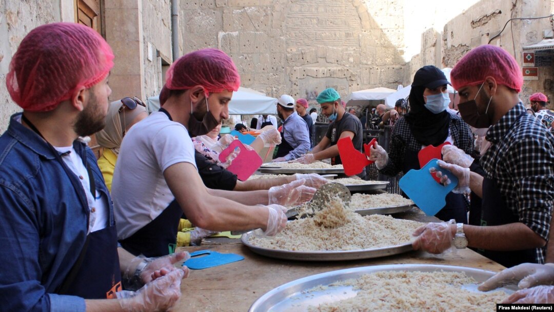 Relawan dari organisasi amal "Saed" menyiapkan makanan untuk dibagikan kepada orang-orang yang membutuhkan selama bulan suci Ramadhan, di Damaskus, Suriah, 23 April 2021. (Foto: REUTERS/Firas Makdesi)