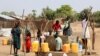 Refugiados sudaneses recolhem água de um furo no campo de refugiados de Gorom. Fotografia de arquivo