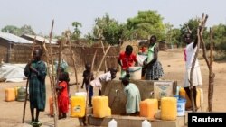 Refugiados sudaneses recolhem água de um furo no campo de refugiados de Gorom. Fotografia de arquivo