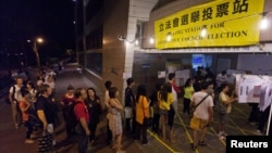 People queue as they wait to cast their votes at a polling station in Hong Kong on September 9, 2012.