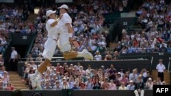 Les tennismen américains Bob Bryan, à droite, et Mike Bryan, a gauche, jubilent après leur victoire sur Rohan Bopanna de l'Inde et Edouard Roger-Vasselin de la France en demi-finale du double-messieurs aux Championnats de tennis de Wimbledon, Londres, 4 juillet 2013.