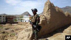 An Afghan commando stands guard at the site of a suicide bomb attack on the outskirts of Kabul, Afghanistan, April 29, 2020. 