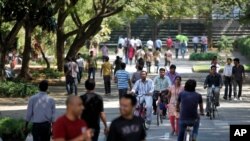 FILE - Employees of Infosys Technologies, the technology outsourcing giant, move inside the company headquarters in Bangalore, India, Jan. 11, 2013. India’s technology and outsourcing industries use H-1B visas to send computer specialists to the U.S.