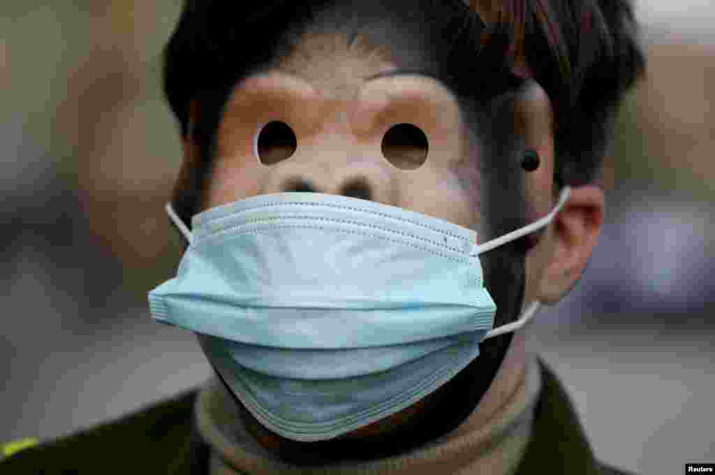 A person wearing a mask depicting a monkey and a face mask takes part in the Global Climate Strike of the movement Fridays for Future in Warsaw, Poland.