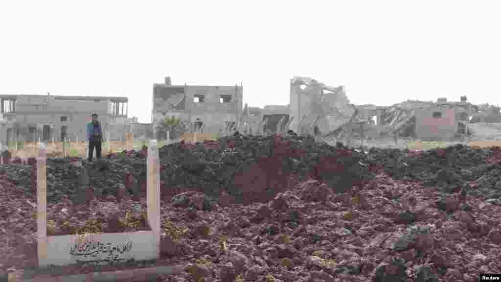 Residents are seen near buildings and a cemetery damaged after a Syrian Air Force fighter jet loyal to Syria's President Bashar al-Assad fired missiles at Taftanaz near Idlib, Syria, November 4, 2012.