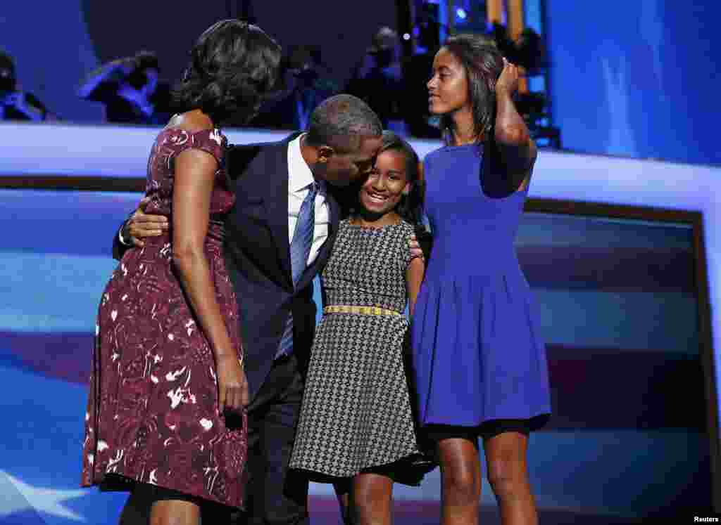 Presiden Barack Obama mencium putrinya Sasha, disaksikan istrinya Michelle dan putri sulungnya Malia, setelah selesai berpidato (6/9). (Reuters)