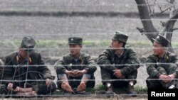 지난해 4월 압록강변에 북한 군인들이 앉아있다. 신의주에 접한 중국측 지역에서 촬영한 사진이다.