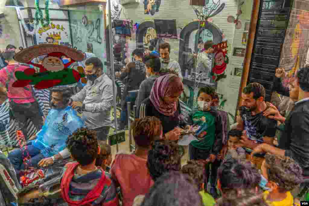 Christian men lined up in front of a barber shop to prepare themselves for the limited festivities in Cairo, Jan. 6, 2021. (H. Elrasam/VOA)