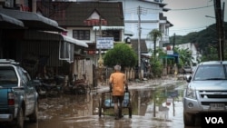 A man pushes bottles of clean water through the flooded areas in Chiang Rai, Thailand, Sept. 22, 2024.
