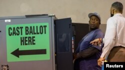 Seorang warga setempat memberikan suaranya menggunakan mesin Dominion Voting System dalam pemilihan paruh waktu di Calvary Baptist Church, Austell, Georgia, AS, 8 November 2022. REUTERS/Carlos Barria