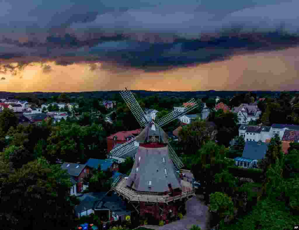 Clouds drift over a windmill in Eutin, northern Germany, during a thunderstorm nearby, July 28, 2021.
