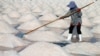 FILE - A woman works on a salt farm in Phetchaburi, Thailand, May 9, 2020. The three main economic industries driving Thailand's gross domestic product are manufacturing, agriculture and services. 