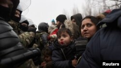 Migrants gather on the Belarusian-Polish border in an attempt to cross it in the Grodno region, Belarus, November 11, 2021. (Ramil Nasibulin/BelTA/Handout via Reuters)