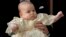 El príncipe William carga a su hijo, el príncipe George, al llegar a la Capilla de St. James. Aparecen su madre, la duquesa de Cambridge, y la Reina Isabel (de espaldas).