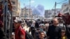 Palestinci u prometnoj ulici u Rafi, u pozadini se vidi dim od eksplozije posle izraelskog vazdušnog udara (Foto: AFP)